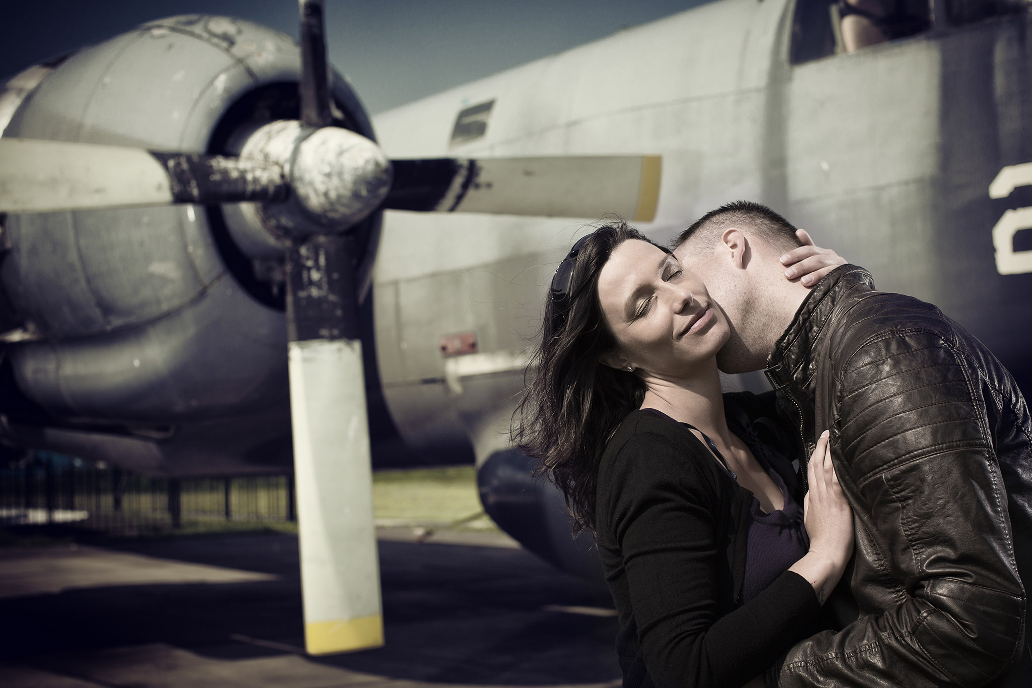 Verliefd koppel in innige omhelzing voor een propeller vliegtuig